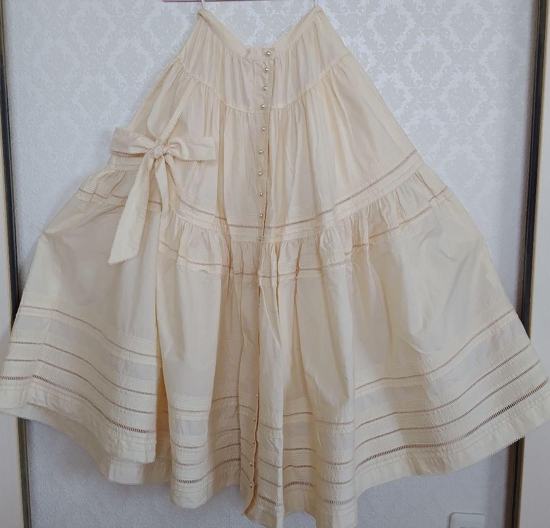 カネコイサオ たくし上げリボン付き クリーム色ロングスカート