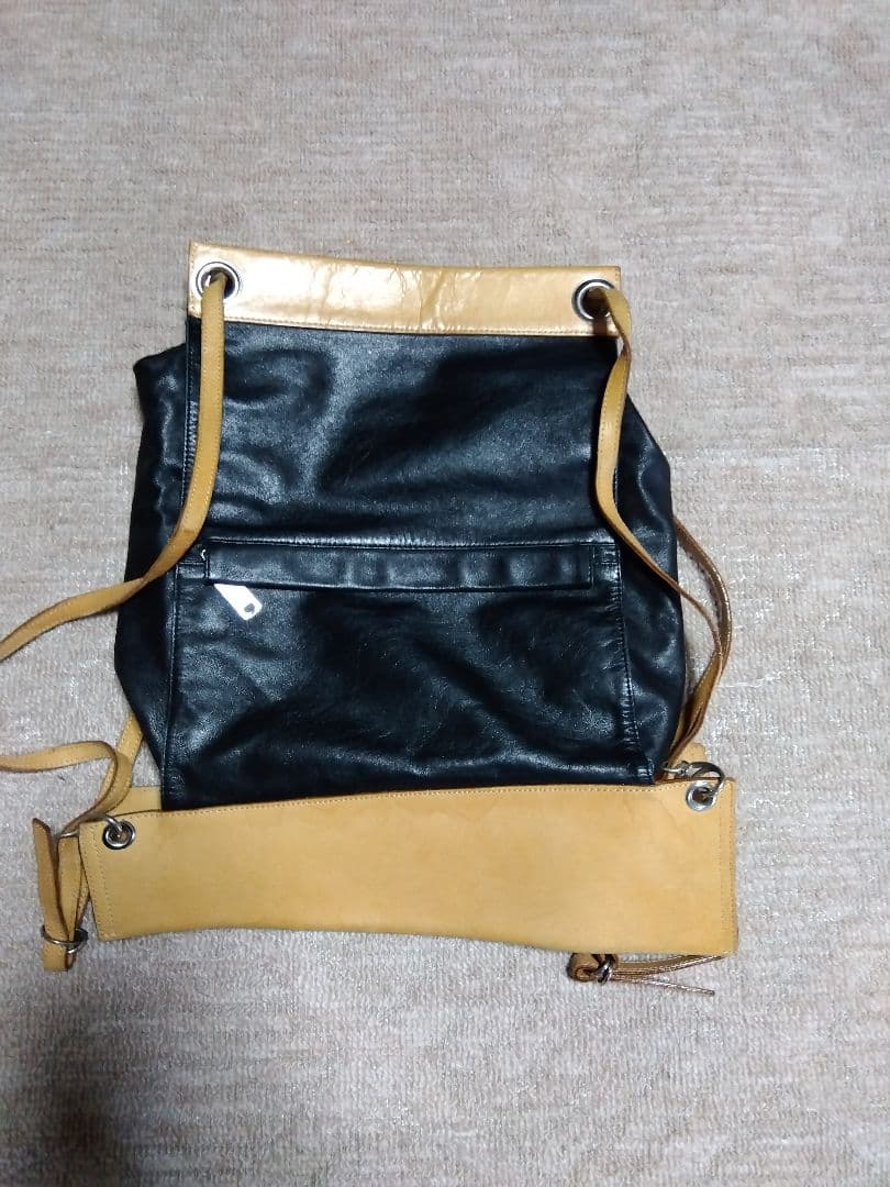 レザー製リュック 黒と黄 Mのロゴ