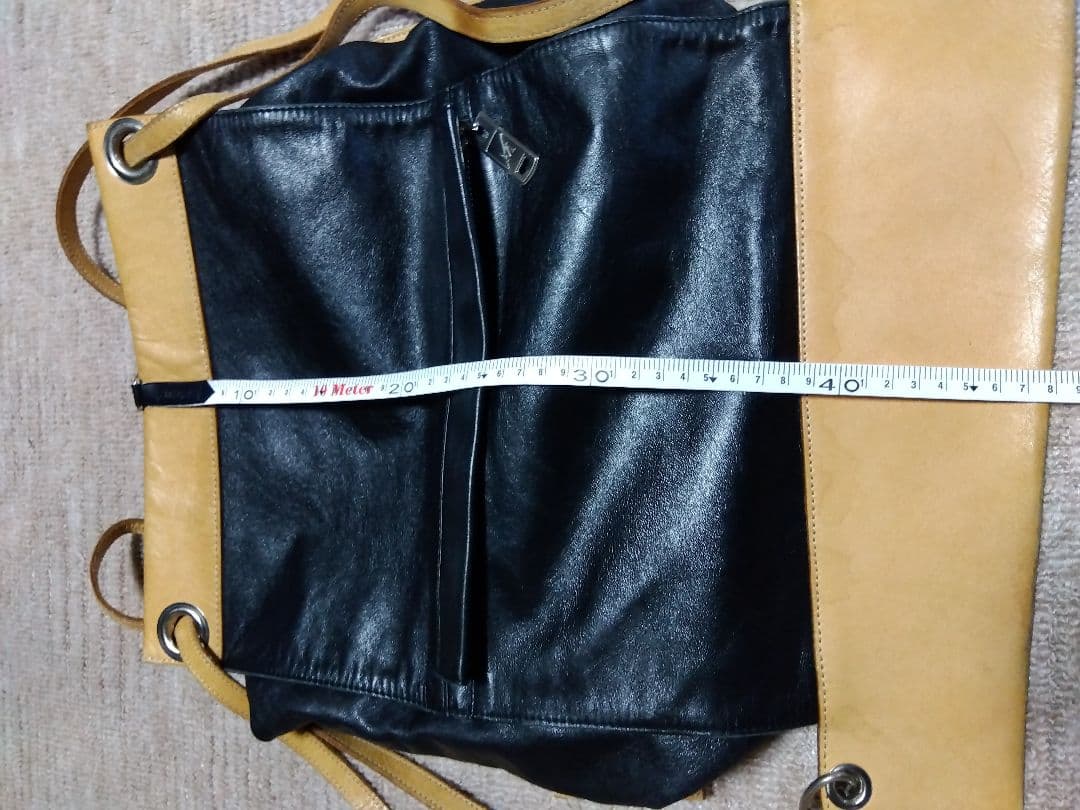 レザー製リュック 黒と黄 Mのロゴ