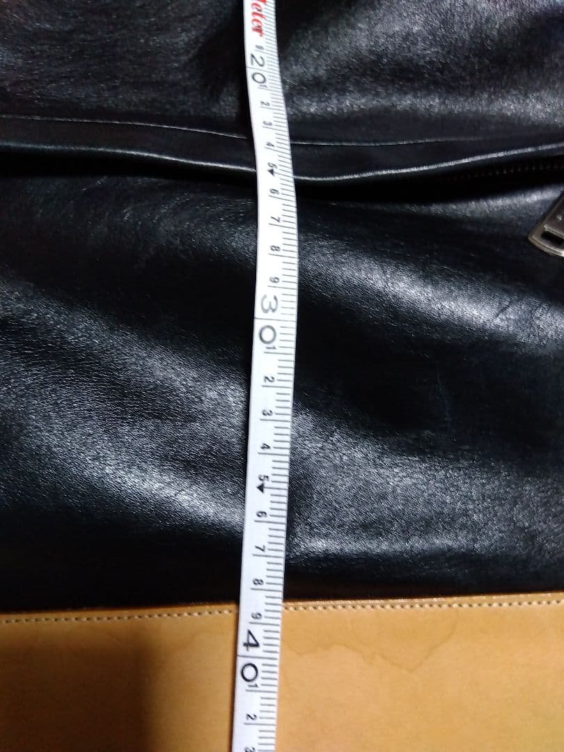 レザー製リュック 黒と黄 Mのロゴ