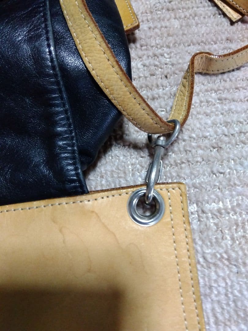 レザー製リュック 黒と黄 Mのロゴ