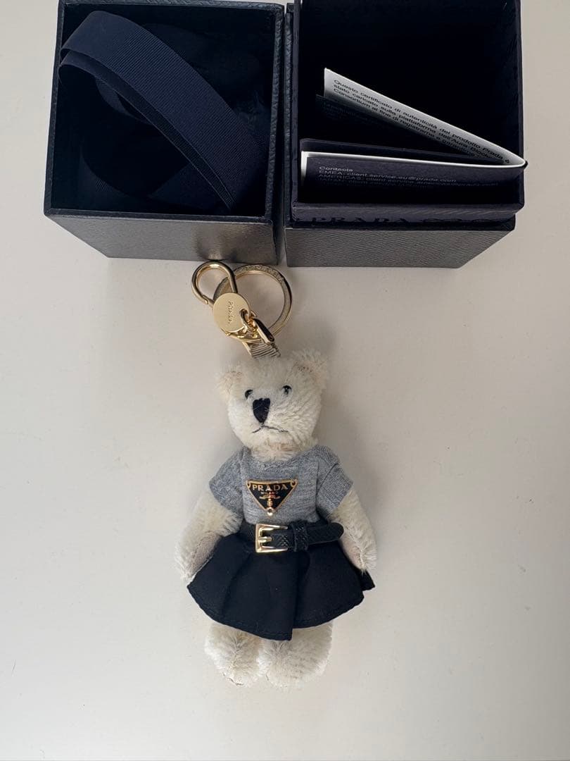 PRADAテディベア型キーホルダー グレーTシャツ 黒スカート