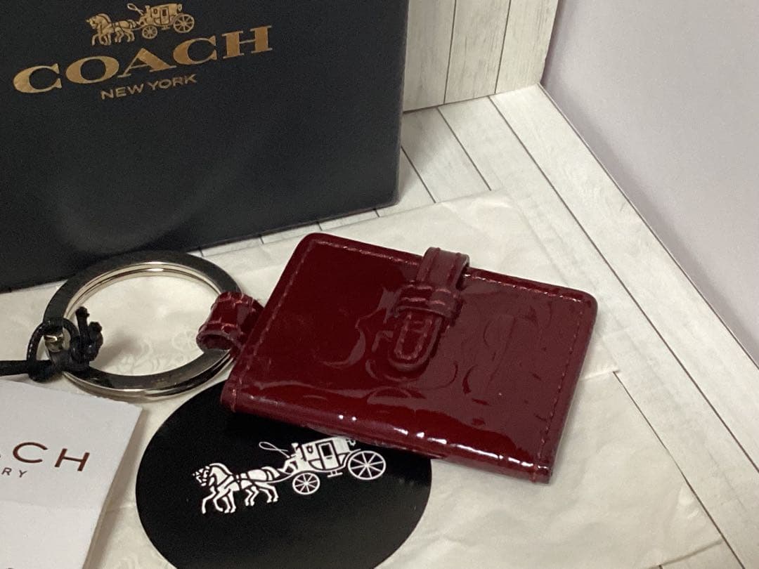 未使用タグ箱付きコーチCOACH エナメルワインレッドキーホルダー写真入れ手帳型