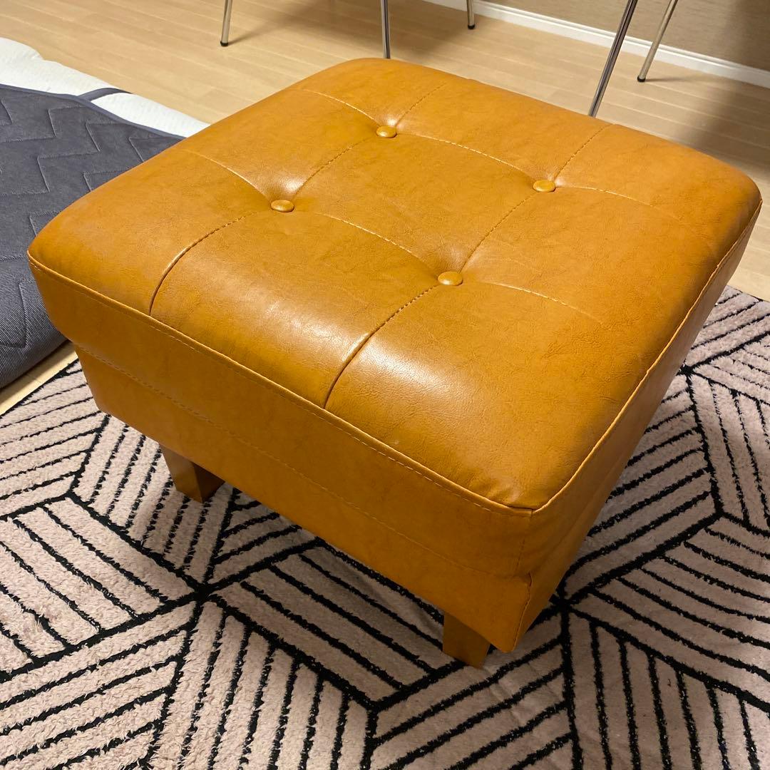 オレンジ色のボタン付きオットマン