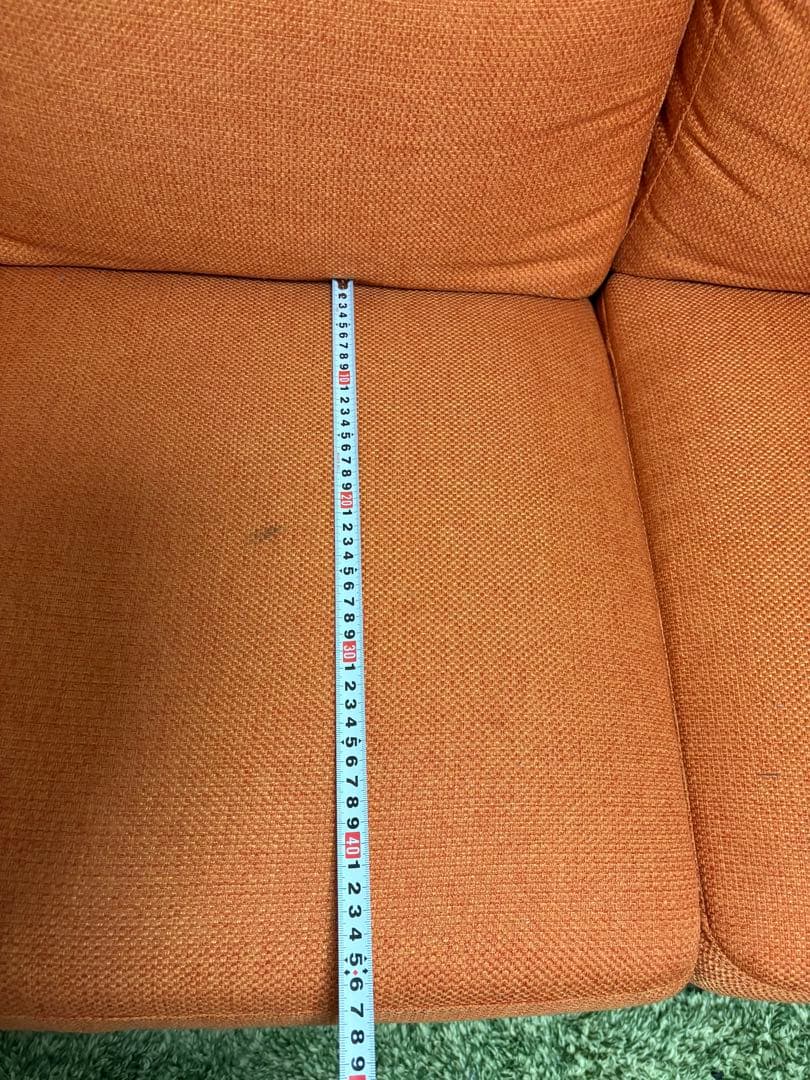 オレンジ色の3人掛けソファ